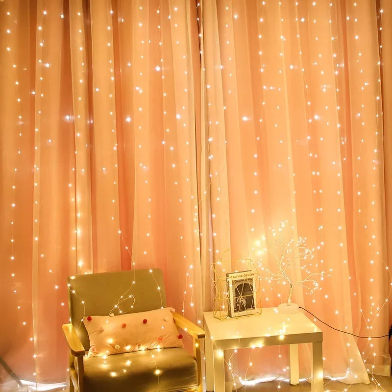 Pink curtain with string lights and a chair with a pillow in a cozy room.