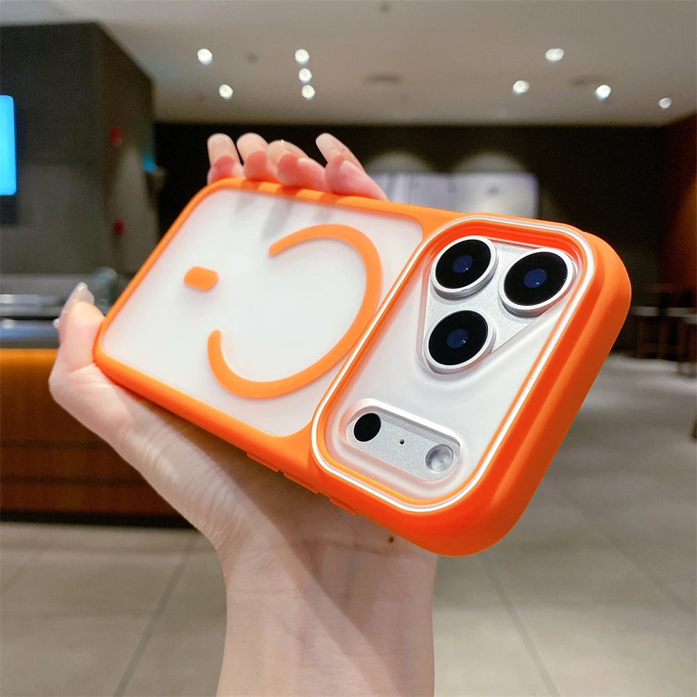 Phone case with a smiley face design held by a hand in an indoor setting
