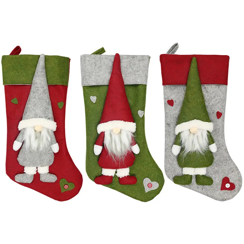 Three Christmas stockings with gnome figures on a white background
