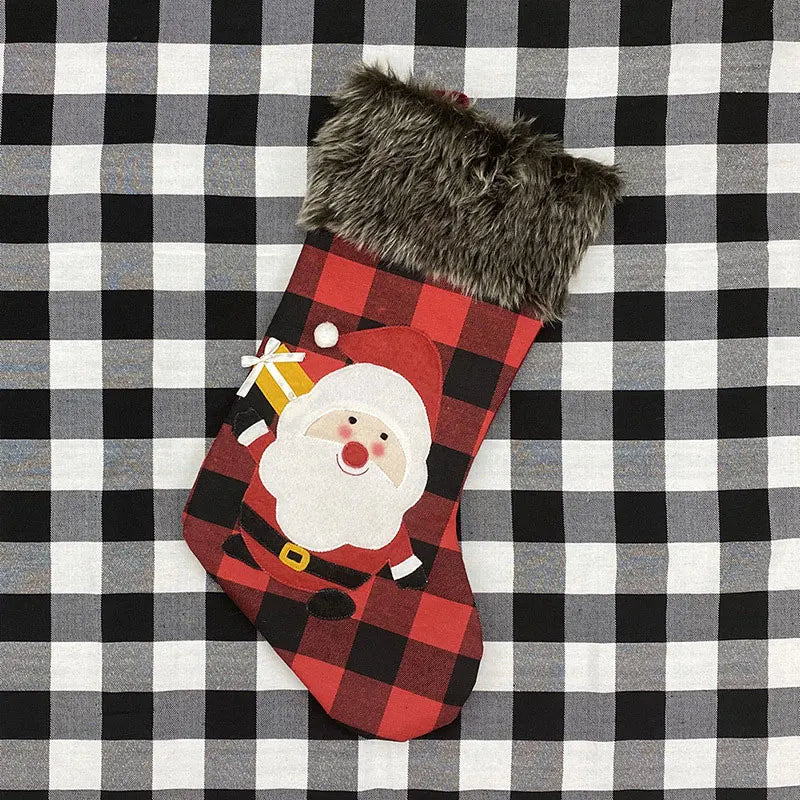 Red and black plaid Christmas stocking with Santa Claus face on a checkered background