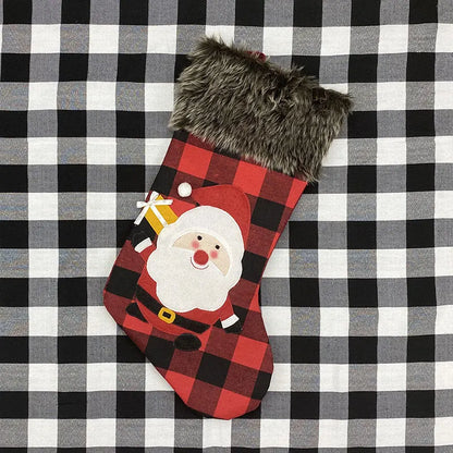 Red and black plaid Christmas stocking with Santa Claus face on a checkered background