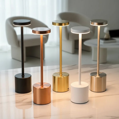 Multiple desk lamps, gold, black, silver , rose , white collars standing on the desk